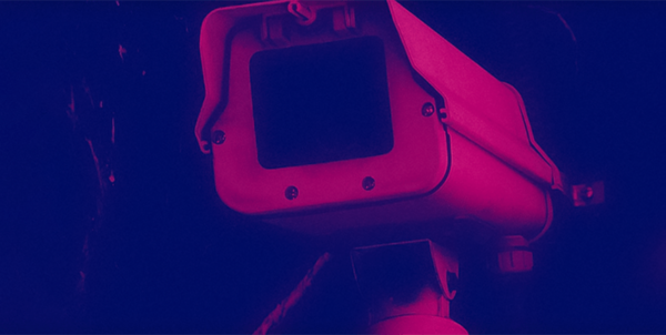 Surveillance camera in dark blue and pink hues representing tscm services that protect against threats